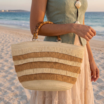 Bolso shopper de paja en tono natural visto desde el frente con asas.