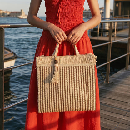 Bolso shopper de paja en tono natural, vista frontal sobre fondo claro.