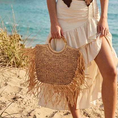 Bolso shopper de paja en vista frontal, mostrando su forma y material.