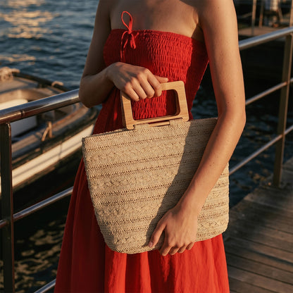Bolso shopper de paja en vista frontal, mostrando su tamaño grande y textura natural.